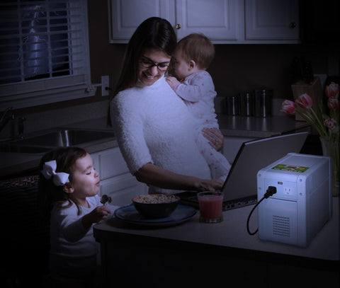 A mom powering her laptop with a kisae solar battery bank during a thunderstorm