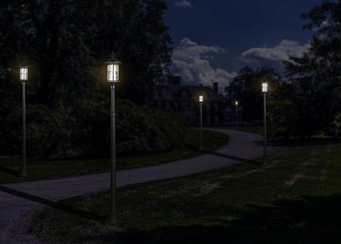 Classy Caps Black Aluminum Hampton Solar Lamps on posts illuminating a driveway path