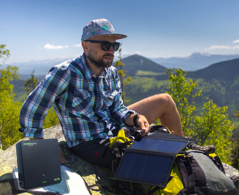 Man hiking using battery pack and foldable solar panel